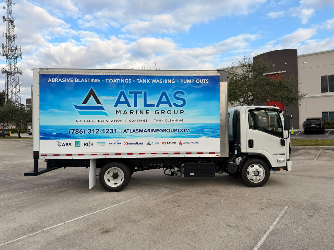 White delivery truck with a large blue Atlas Marine Group banner advertising surface preparation, coatings, tank washing and pump outs, with phone and website listed.