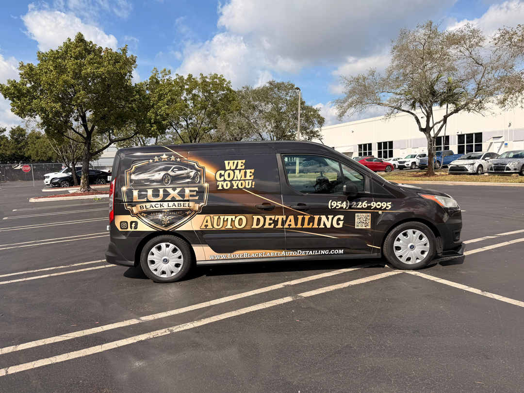 Black detailing van in a parking lot advertising Luxe Black Label Auto Detailing with We Come To You slogan and contact number (954) 226-9095.