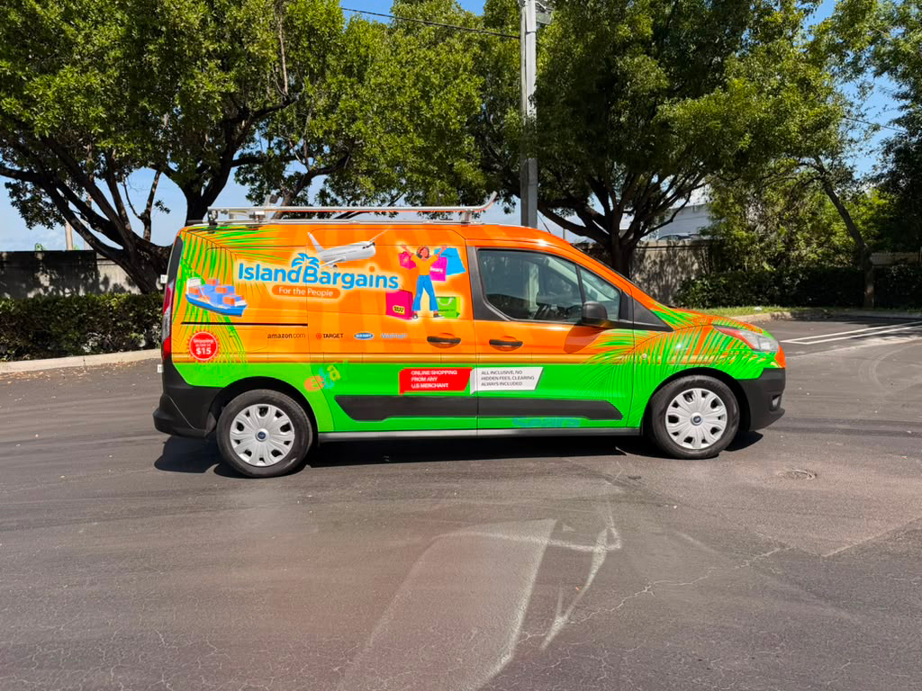 Bright orange and green promotional van with 'Island Bargains' branding parked in a lot, tropical graphics on the sides.