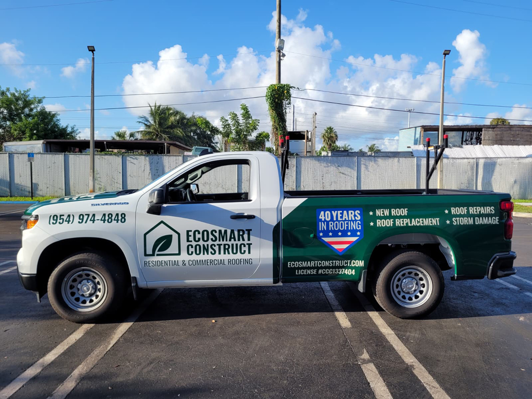White and green EcoSmart Construct roofing truck parked in a lot, showing logos and contact info