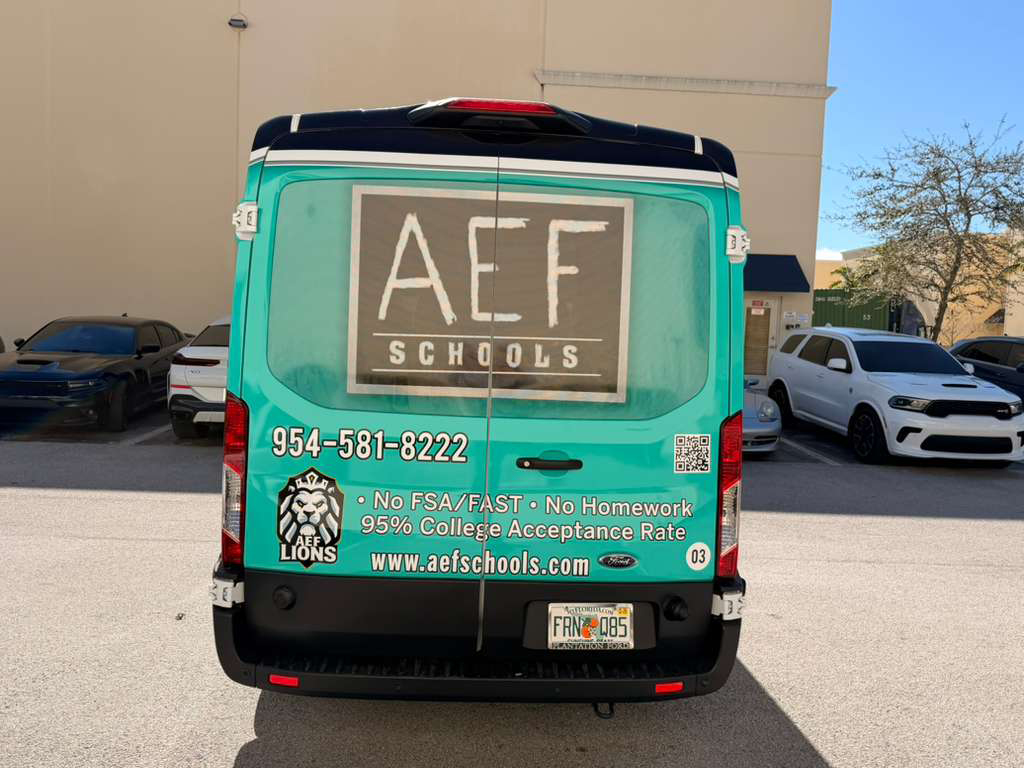 Back of teal AEF Schools promotional van with large logo, contact number, and bullet points about no homework and 95% college acceptance in a parking lot.