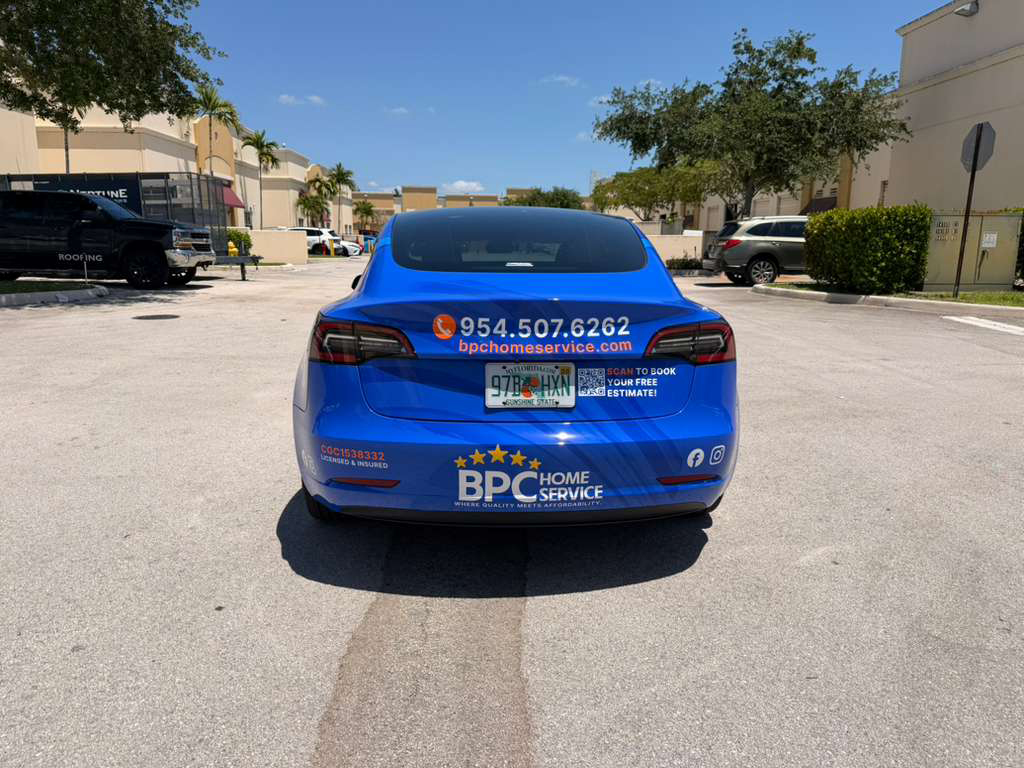 Blue sedan parked in a lot with BPC Home Service advertising on the trunk, including phone number and logo text visible.